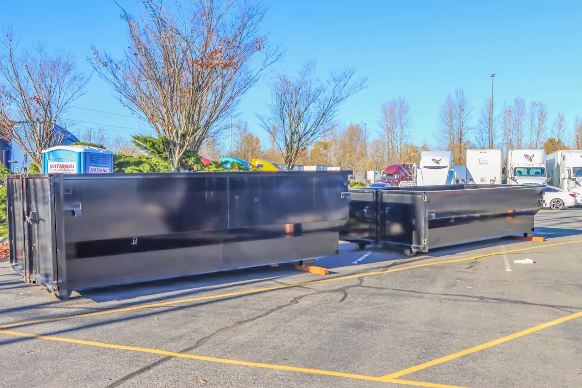 Professional dumpster rental service with roll-off container on residential driveway in Seven Oaks